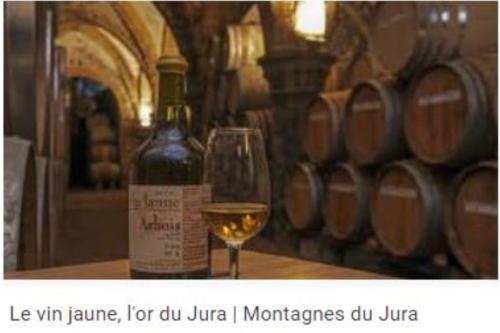 - un verre de vin blanc à côté d'une bouteille de vin dans l'établissement Les Bergeronnettes, à Trénal