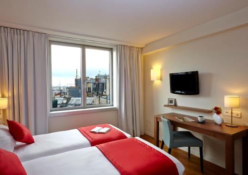 فندق سيتادينز بلاس دي إيطالي باريس في باريس: غرفه فندقيه بسرير ومكتب ونافذه