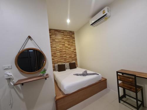 um pequeno quarto com uma cama e um espelho em Samed Your House em Ko Samet