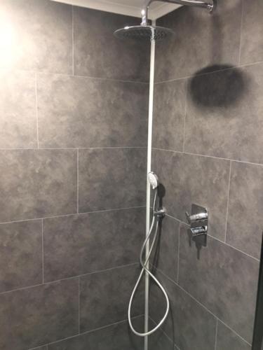 a shower with a hose in a bathroom at Genieterke in Somme-Leuze