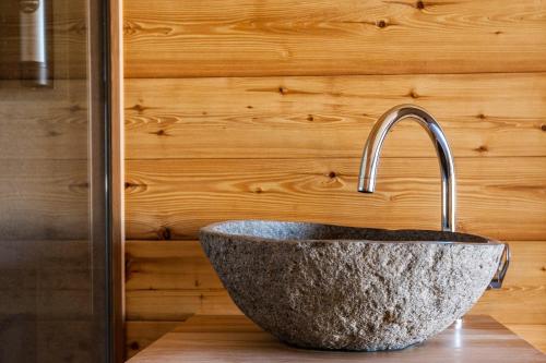 kamienna umywalka w łazience z drewnianą ścianą w obiekcie Glamping Kranjc w mieście Kobarid