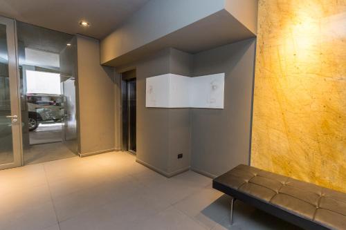 a lobby with a bench in a building at Babel Belgrano in Buenos Aires