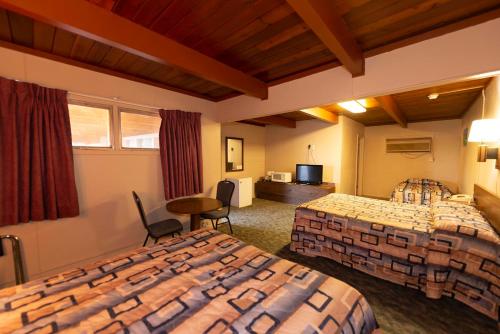una camera d'albergo con due letti e una televisione di Cedar Inn a McCook