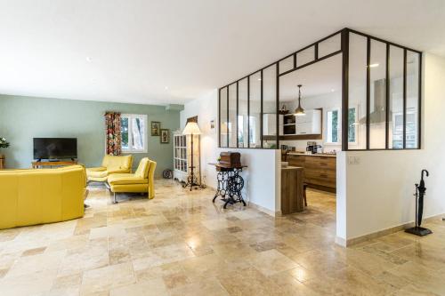 un salon avec un canapé jaune et une cuisine dans l'établissement Stunning house on the edge of the Luberon, à Cheval-Blanc