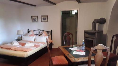 a bedroom with a bed and a table with a fireplace at Hotel-Restaurant Bergmühle in Bayreuth