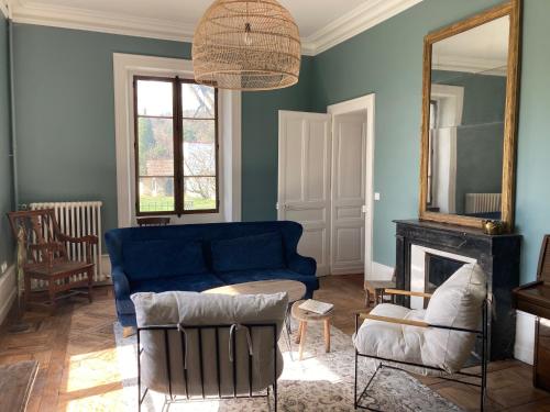 a living room with a blue couch and a mirror at Domaine Jacqueline Père & Filles in Aix-les-Bains