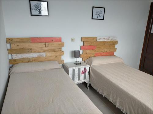 1 dormitorio con 2 camas y pared en Pensión Oyambre, en San Vicente de la Barquera