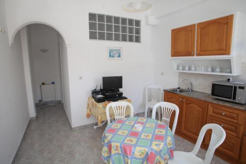 a kitchen with a table and chairs and a microwave at Afroditi Syros in Ermoupoli