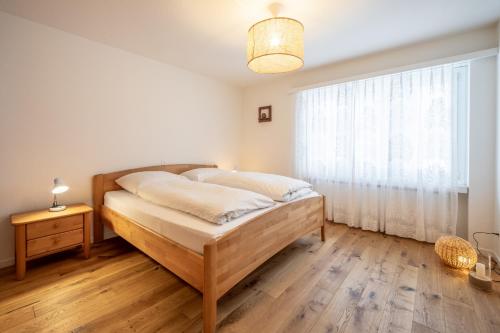 - une chambre avec un lit et une grande fenêtre dans l'établissement LAAX Homes - Val Signina 7-12, à Laax