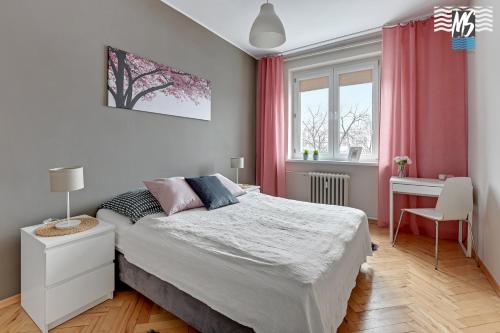 a bedroom with a large bed and a desk at MS Apartments Centrum Gdyni I in Gdynia