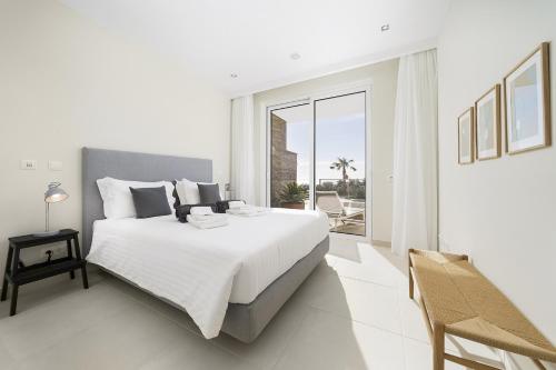- une chambre blanche avec un grand lit et un balcon dans l'établissement Brand New Luxury 3 Bedroom Apartment, Porto de Mos, à Porto de Mós
