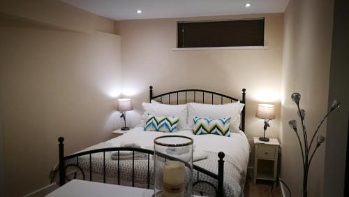 um quarto com uma cama com duas mesas de cabeceira e dois candeeiros em Lowghyll suite em Bowness-on-Windermere