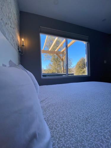 a bedroom with a bed and a large window at Inner Joy Getaways in Elora