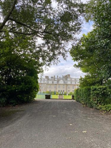 a large building in the middle of a park with trees at Gleneagles Luxury Apartments in Auchterarder