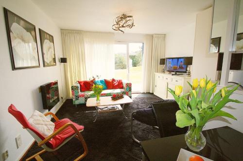 a living room with a couch and a table at Comfort-Appartement ZEEDUIN, op Beg grond met Terras - volledige KEUKEN - Resort Amelander Kaap met gebruik van verwarmd Hotel-ZWEMBAD in Hollum