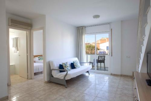 sala de estar con sofá blanco y ventana en Apartamentos La Torreta, en Altafulla