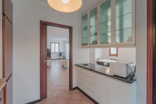 a kitchen with a counter with a microwave in it at Casa Mary Tre - attico con terrazza a 2 passi dal lago in Sirmione