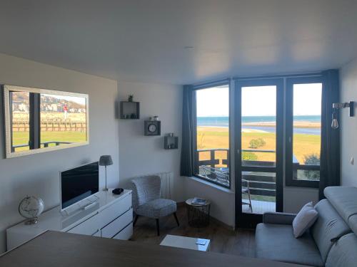 a living room with a couch and a television at Les Marinas Port Deauville in Deauville