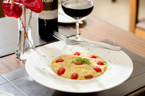 a plate of food on a table with a glass of wine at Mercure Sao Paulo JK in Sao Paulo