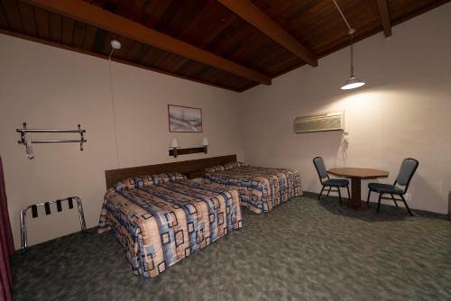 a bedroom with two beds and a table and chairs at Cedar Inn in McCook