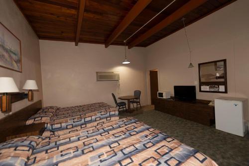 a hotel room with two beds and a table at Cedar Inn in McCook