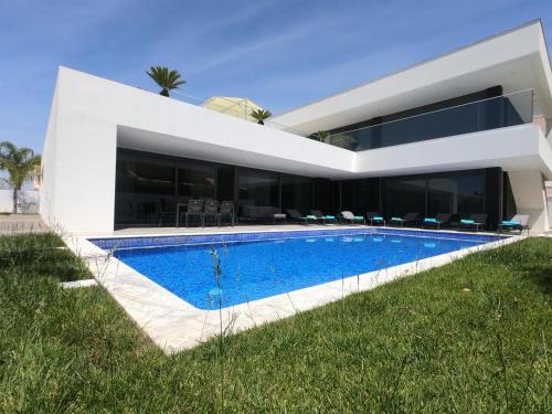 une maison avec une piscine en face de celle-ci dans l'établissement Luxury Villa Aleana, à Portimão