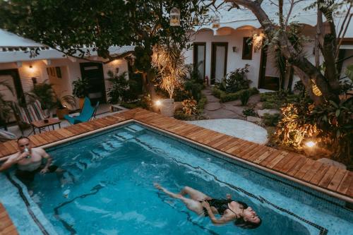 two people are swimming in a swimming pool at Amaia Boutique Hotel in Sayulita