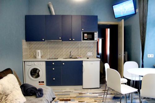 利沃夫Apartment in blue в історичному центрі міста的厨房配有蓝色橱柜和洗衣机。