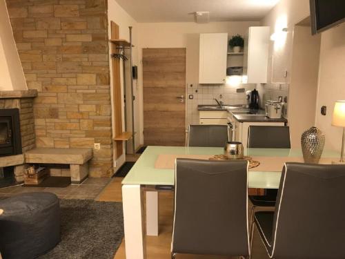 eine Küche mit einem Tisch und Stühlen sowie einem Kamin in der Unterkunft Apartment am Bikepark mit Kamin und Sauna in Winterberg