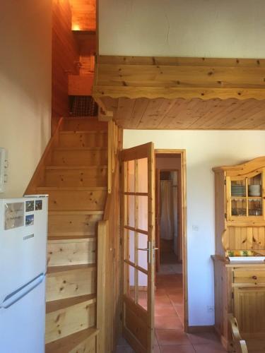 - une cuisine avec un escalier en bois et un réfrigérateur dans l'établissement Le Cubèt Hameau des Chazals Nevache Hautes Alpes, à Névache