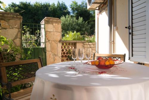 a table with a bowl of fruit and wine glasses at Villa Anna in Savudrija