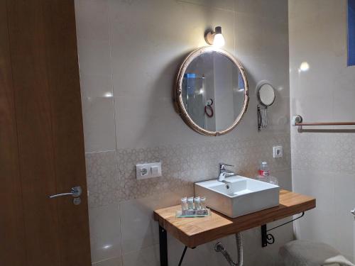 uma casa de banho com um lavatório e um espelho em La Lagareta de Olivia em Trevejo