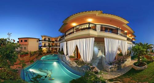 un gran edificio con piscina frente a una casa en Giannis & Foteini, en Afitos