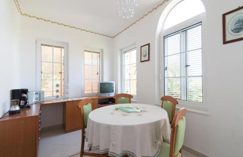 a dining room with a table and some windows at Villa Anna in Savudrija