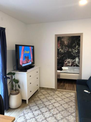 a living room with a flat screen tv on a dresser at Városi Menedék in Veszprém