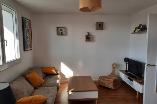 uma sala de estar com um sofá e uma mesa em appartement 70m² 3 chambres avec 3 lits 2 places em Troyes