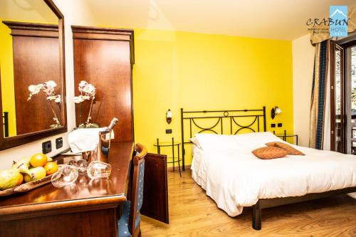 a bedroom with a bed and a table with a mirror at Crabun Hotel in Pont-Saint-Martin
