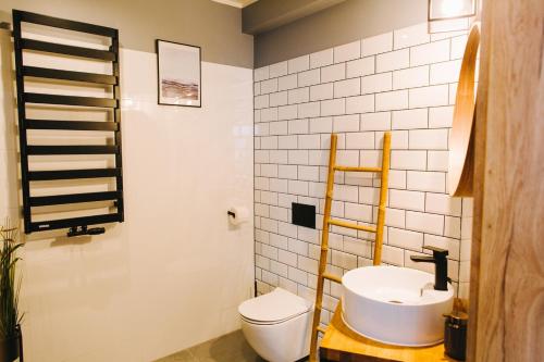 a bathroom with a white toilet and a sink at Apartamenty 'Okno z widokiem' in Wisła