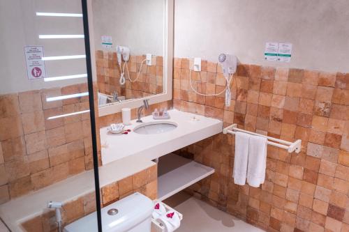 een badkamer met een wastafel, een douche en een toilet bij Pipa Privilege Suítes in Pipa