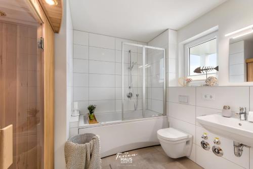 een badkamer met een bad, een toilet en een wastafel bij Pierstern 53 in Olpenitz