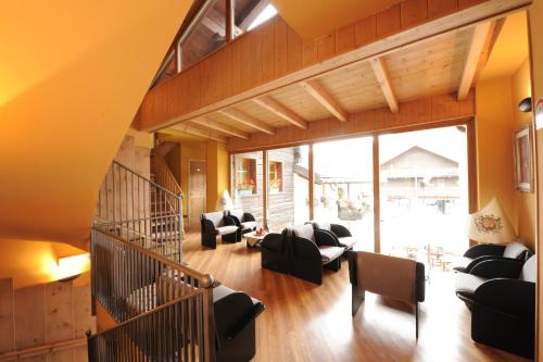 a living room with couches and a staircase at Hotel Astra in Livigno