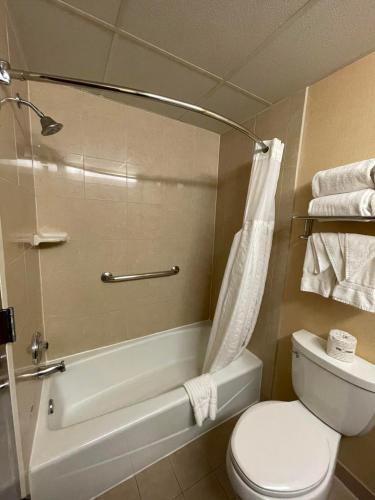 a bathroom with a toilet and a tub and a sink at Comfort Inn Ballston in Arlington