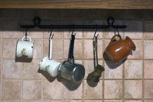 a group of pots and pans hanging on a wall at Lithia s Stonehouse. Το πέτρινο στη Λιθιά - Καστοριά in Lithiá