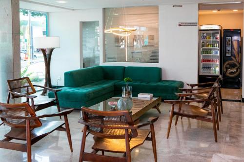 a living room filled with furniture and a tv at Castelo Inn Hotel in Goiânia
