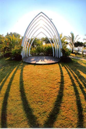 a white arch in the middle of a grass field at Fu Wan Cafe Villa in Donggang