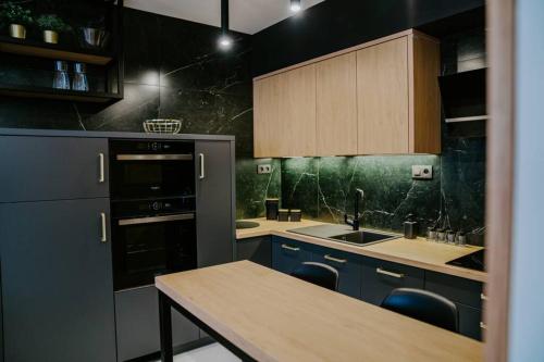 cocina con armarios azules y encimera en APARTMENT A&D Downtown en Poprad