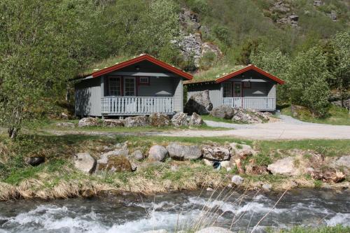 two cottages on the side of a river at Melkevoll Bretun Camping in Stryn