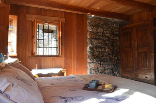 a bedroom with a bed with a tray of food on it at LA MURA’ - Il vostro posto nel Gran Paradiso in Ronco Canavese