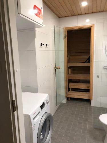 bagno con lavatrice e doccia di Niittylä Apartments a Rovaniemi