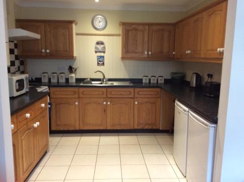 a kitchen with wooden cabinets and a sink at 9 Afton Barns in Freshwater